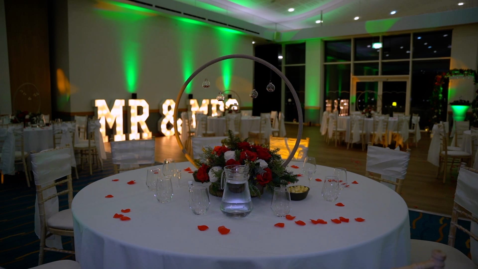 Conference Suite set for a wedding with green uplighters and large MR and MRS neon letters.